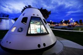a replica Apollo space capsule sits outside the planetarium at dusk